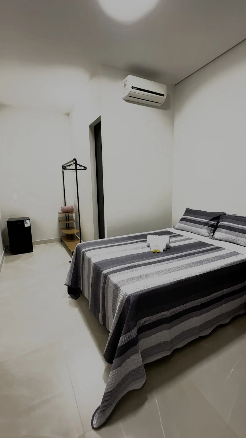 Quarto com cama de casal e colcha listrada