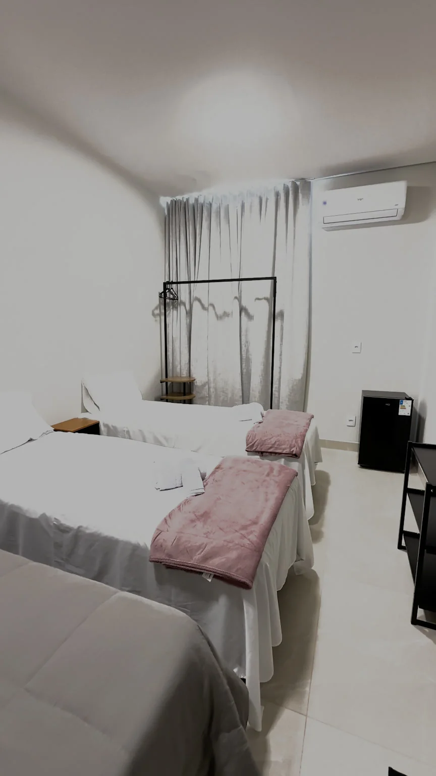 Quarto com camas individuais e mantas rosadas